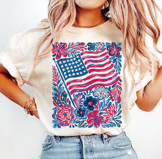 Person wearing a white t-shirt with an American flag and floral design.