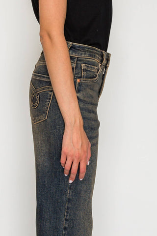 Person wearing blue jeans with a plain background